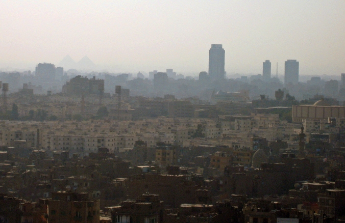 Picture of polluted Cairo skyline with pyramids visible in background